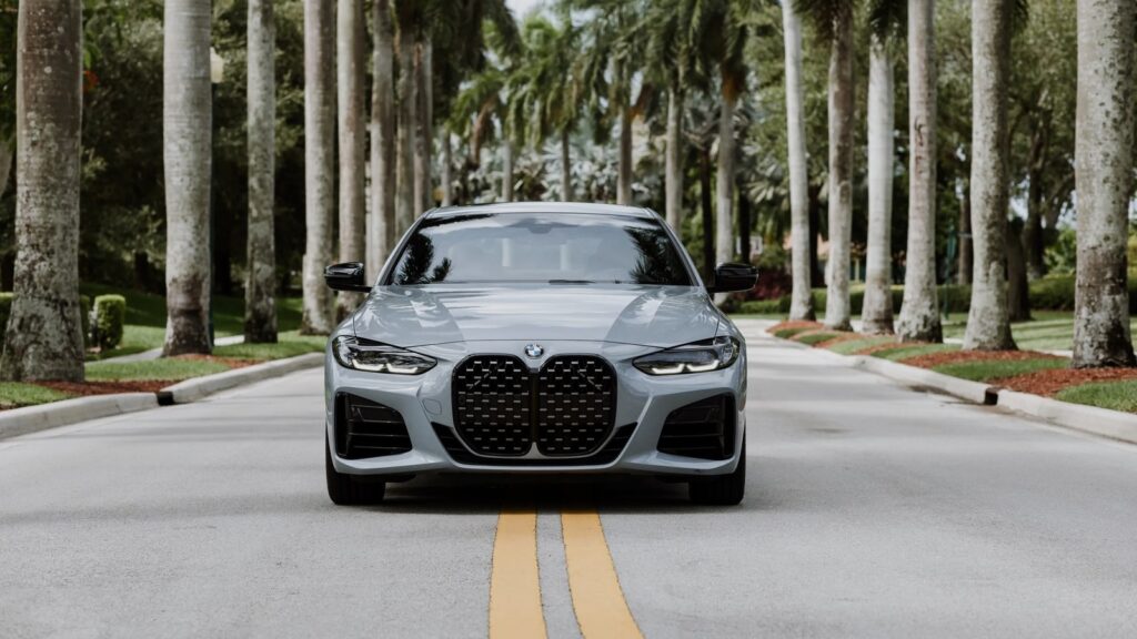 Grey BMW 4 Series rental in Fort Lauderdale palm-lined avenue — Turtur Luxury Cars
