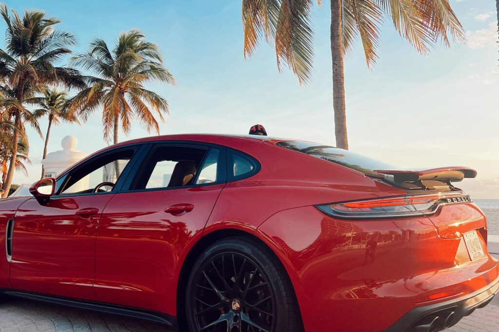 Red Porsche Panamera at sunset with palms in Fort Lauderdale — Turtur Luxury Cars